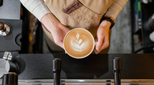 A barista holding a coffee